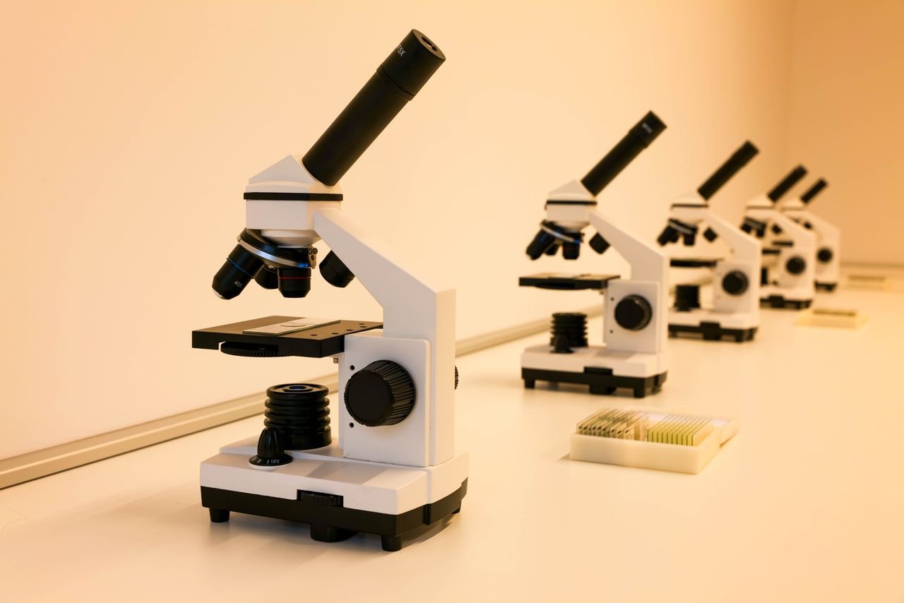 why-choose-us A series of microscopes on a lab table, ideal for scientific research and education.